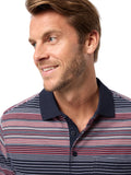 Man wearing a striped polo shirt with a neutral background