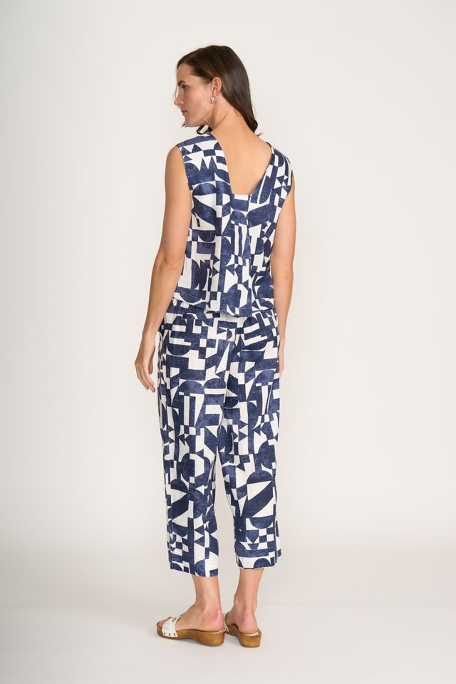 Woman wearing a blue and white geometric patterned jumpsuit on a white background