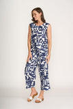 Woman wearing a blue and white geometric patterned jumpsuit on a white background