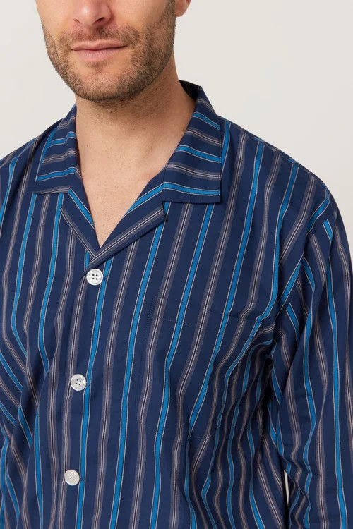 Man wearing a navy and blue striped pajama shirt against a plain background