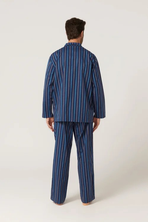 Man wearing a blue striped pajama set on a white background