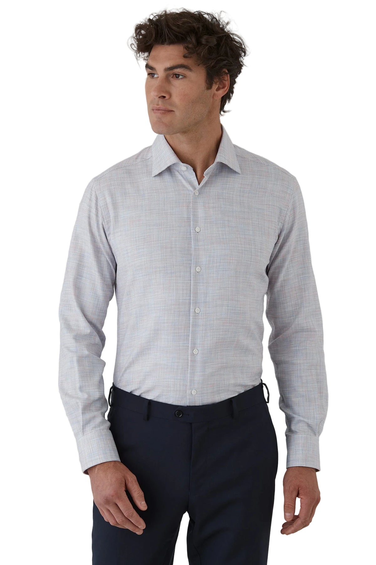 Man wearing a light gray checkered shirt and dark pants on a white background