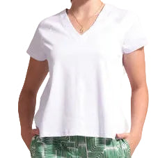 Woman wearing a white top and green patterned pants on a plain background