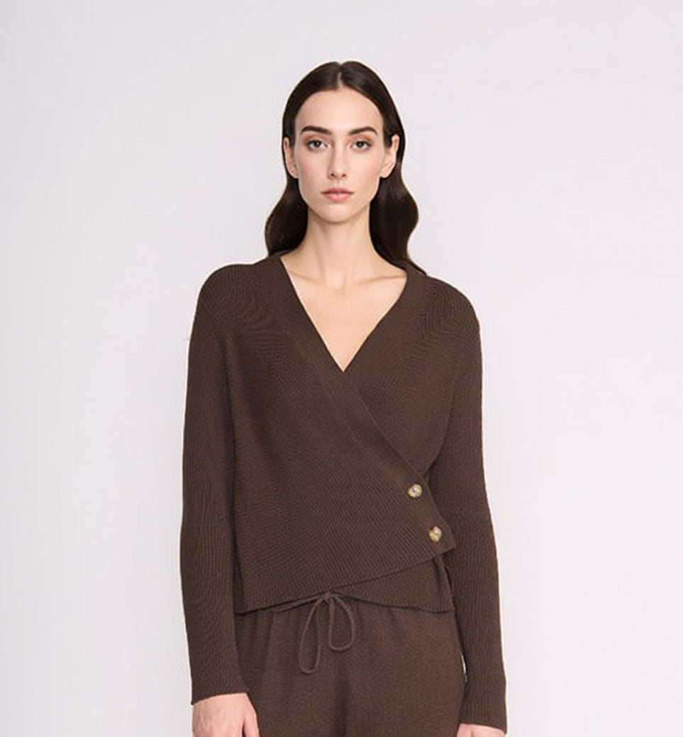 Woman wearing a brown outfit with a matching cardigan and pants on a white background
