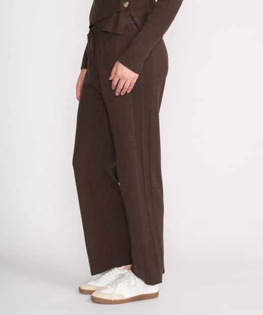 Woman wearing a brown suit with white shoes on a white background
