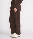 Woman wearing a brown suit with white shoes on a white background