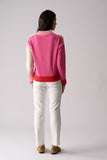 Person wearing a pink sweater with a white background