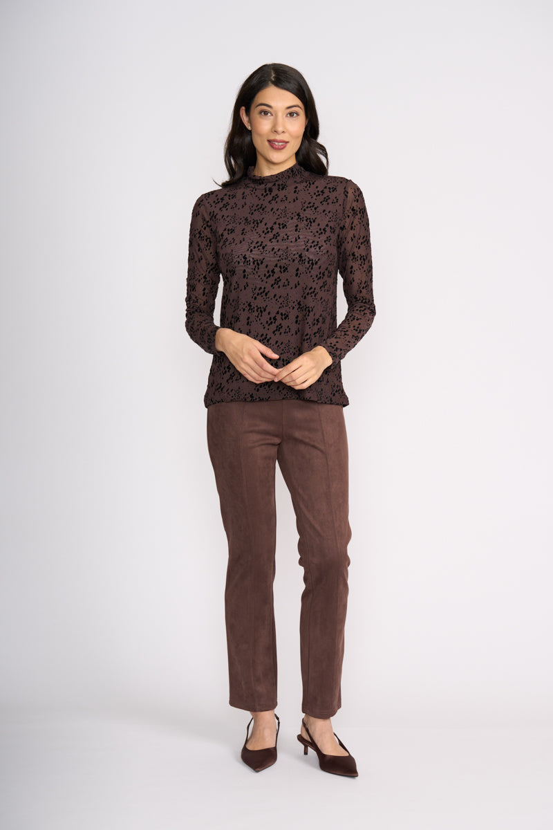 Woman wearing a brown patterned top and matching pants on a white background