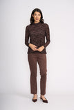 Woman wearing a brown patterned top and matching pants on a white background