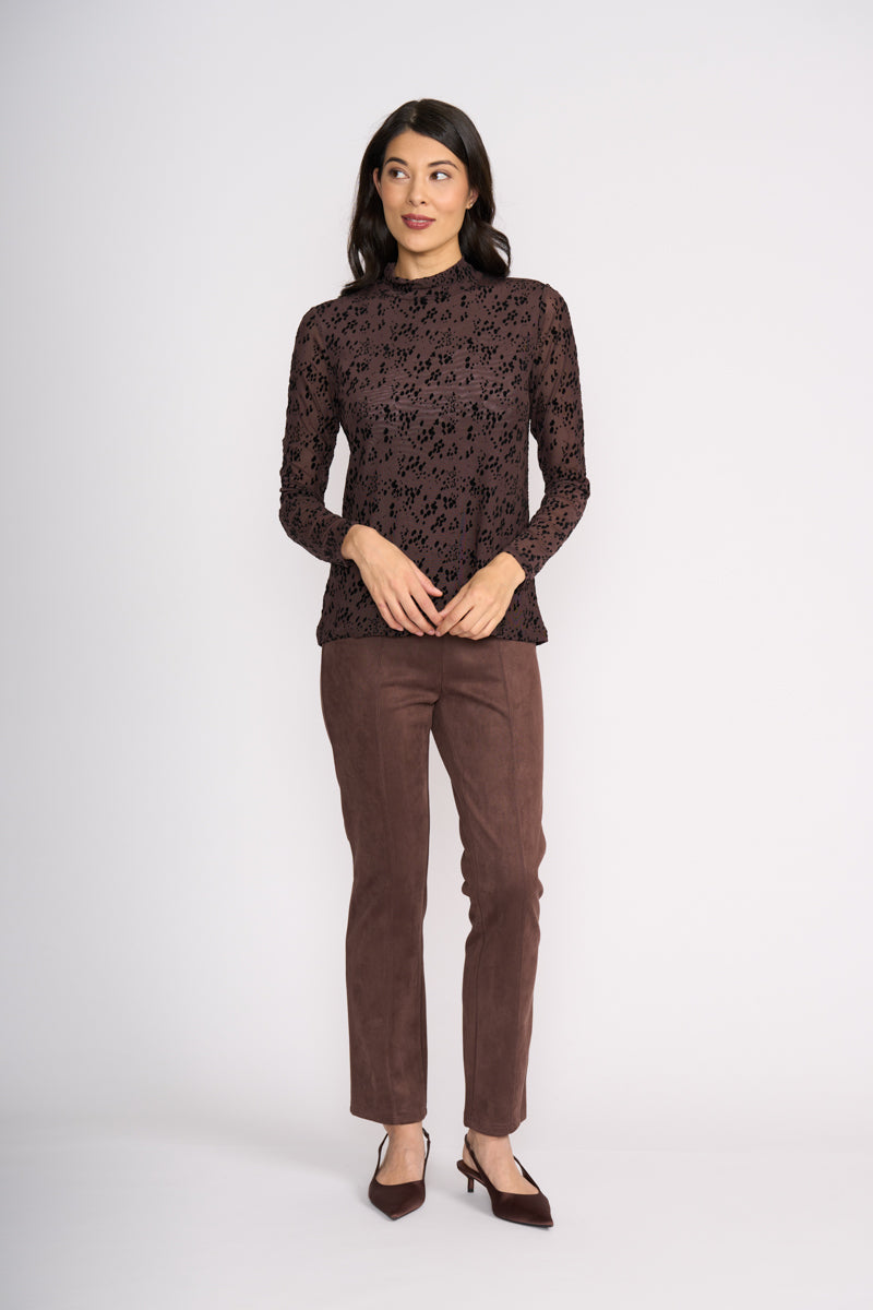 Woman wearing a brown patterned top and matching pants on a white background