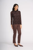 Woman wearing a brown patterned top and brown pants on a white background