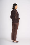Woman wearing a brown floral blouse and brown pants on a white background