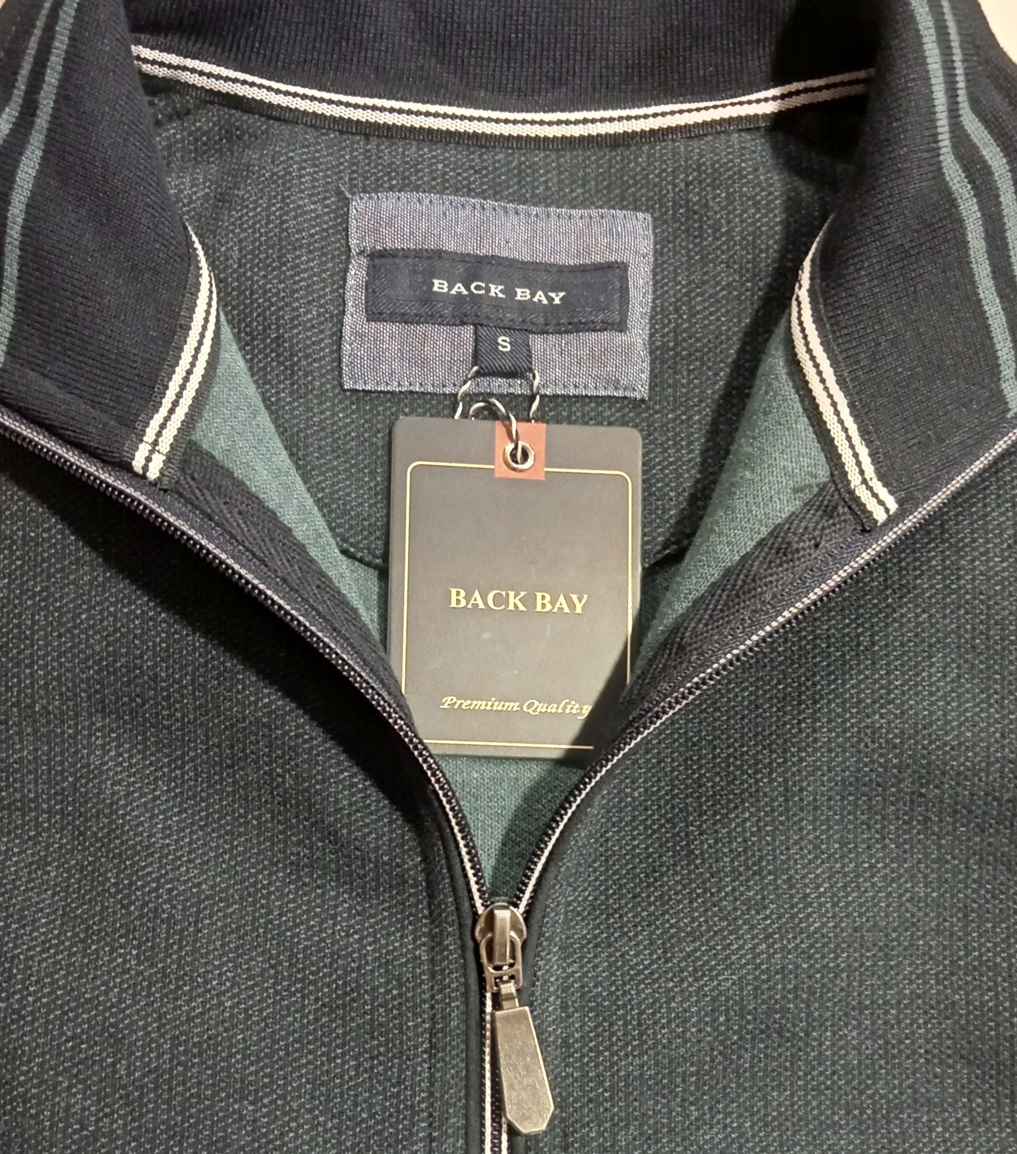 Folded dark gray jacket with a brand tag on a light background