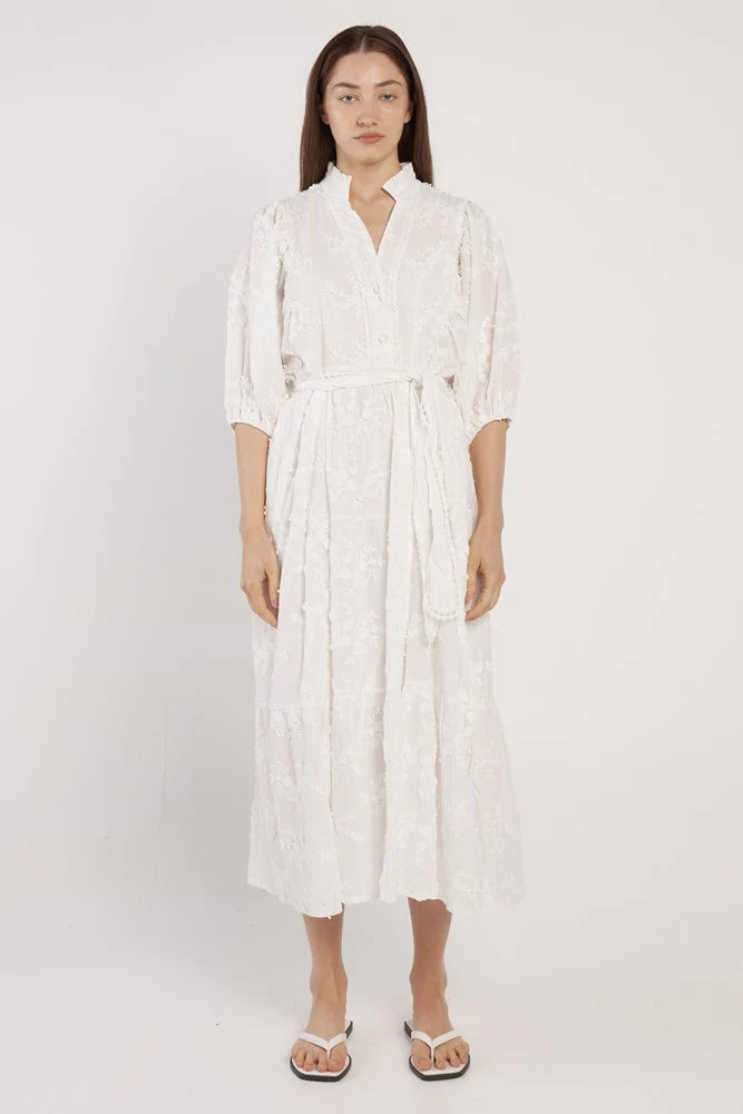 Woman wearing a white dress on a plain background