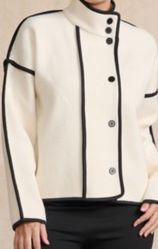 White jacket with black accents and buttons on a neutral background