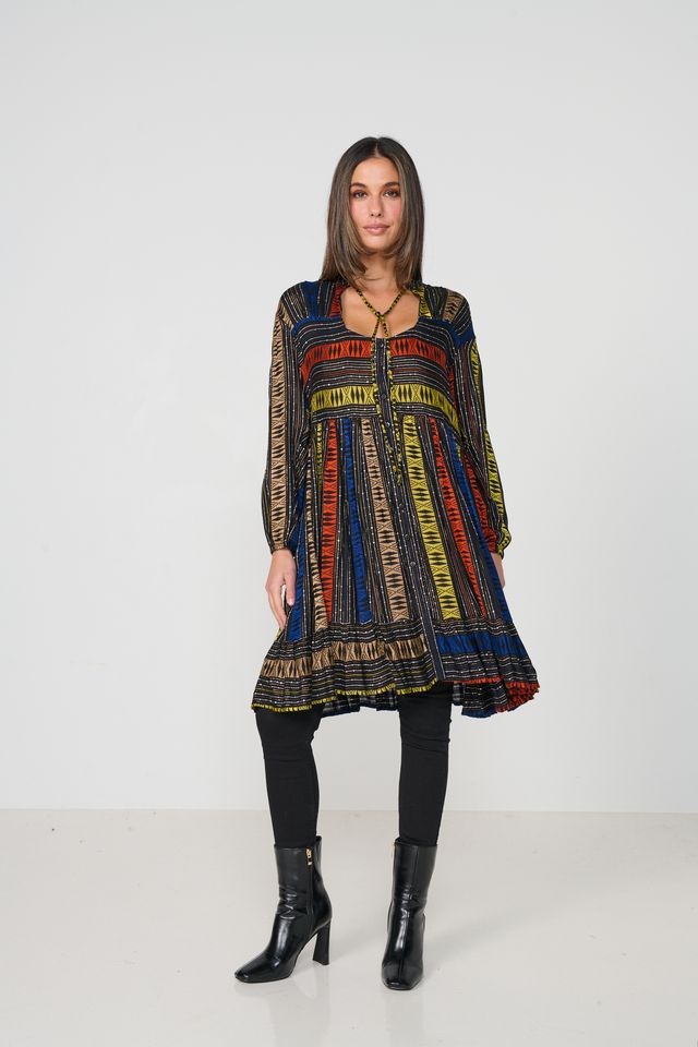 Woman wearing a colorful patterned dress on a white background