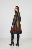 Woman wearing a colorful patterned dress on a white background