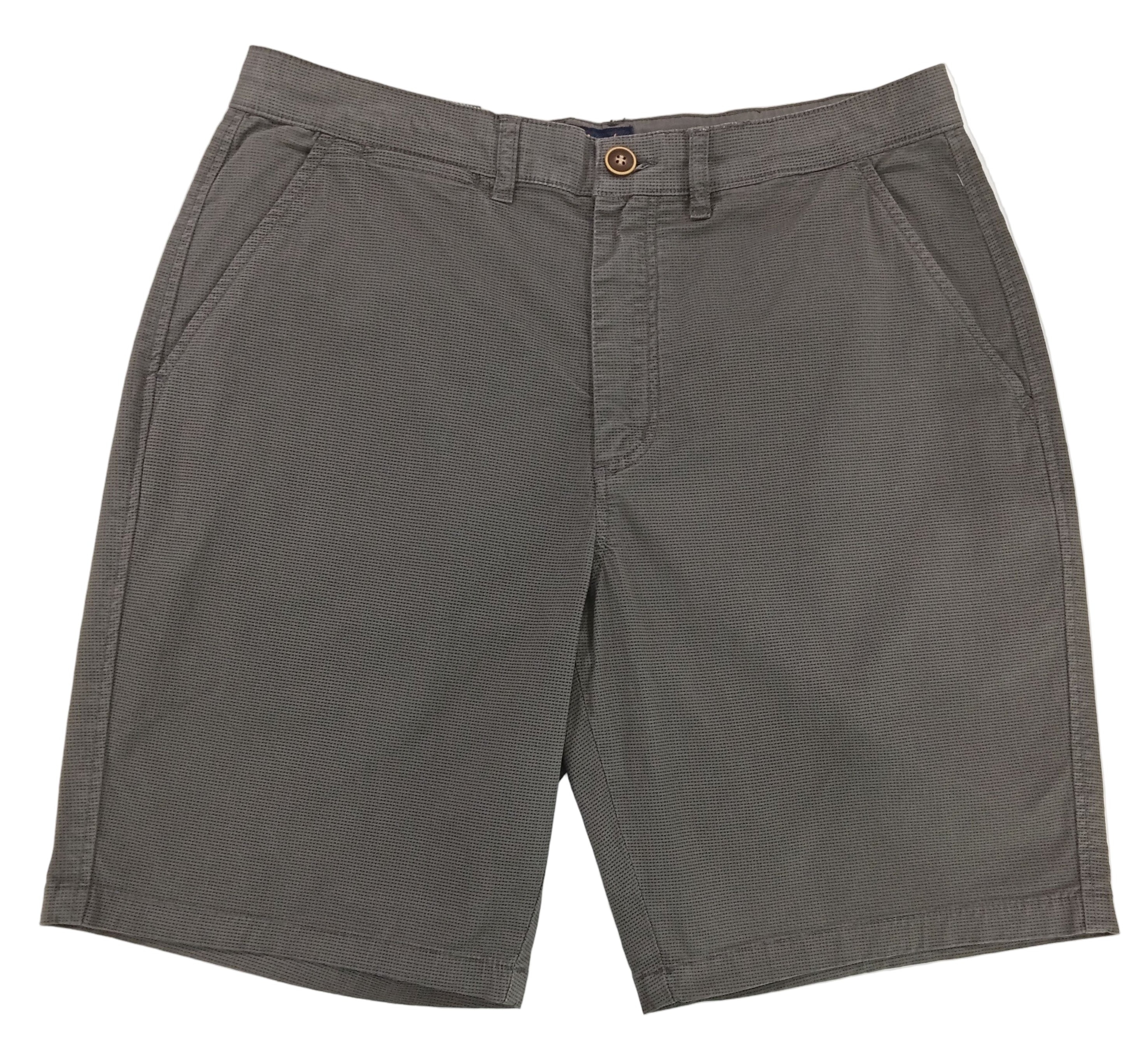 Gray shorts on a white surface with a textured gray background