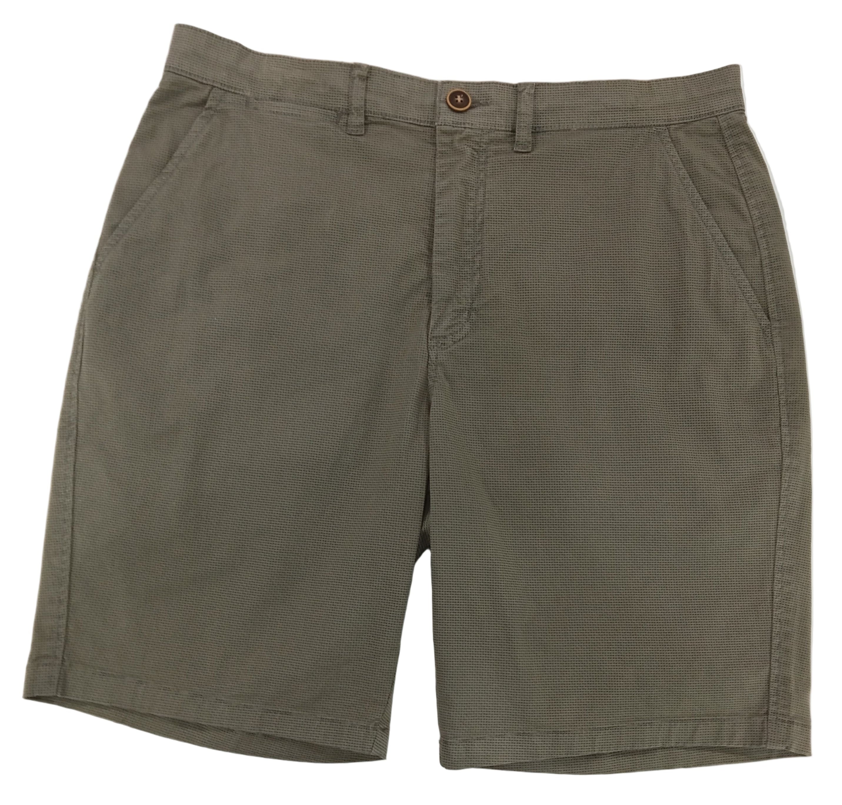 Pair of green shorts on a white surface with a blurred background