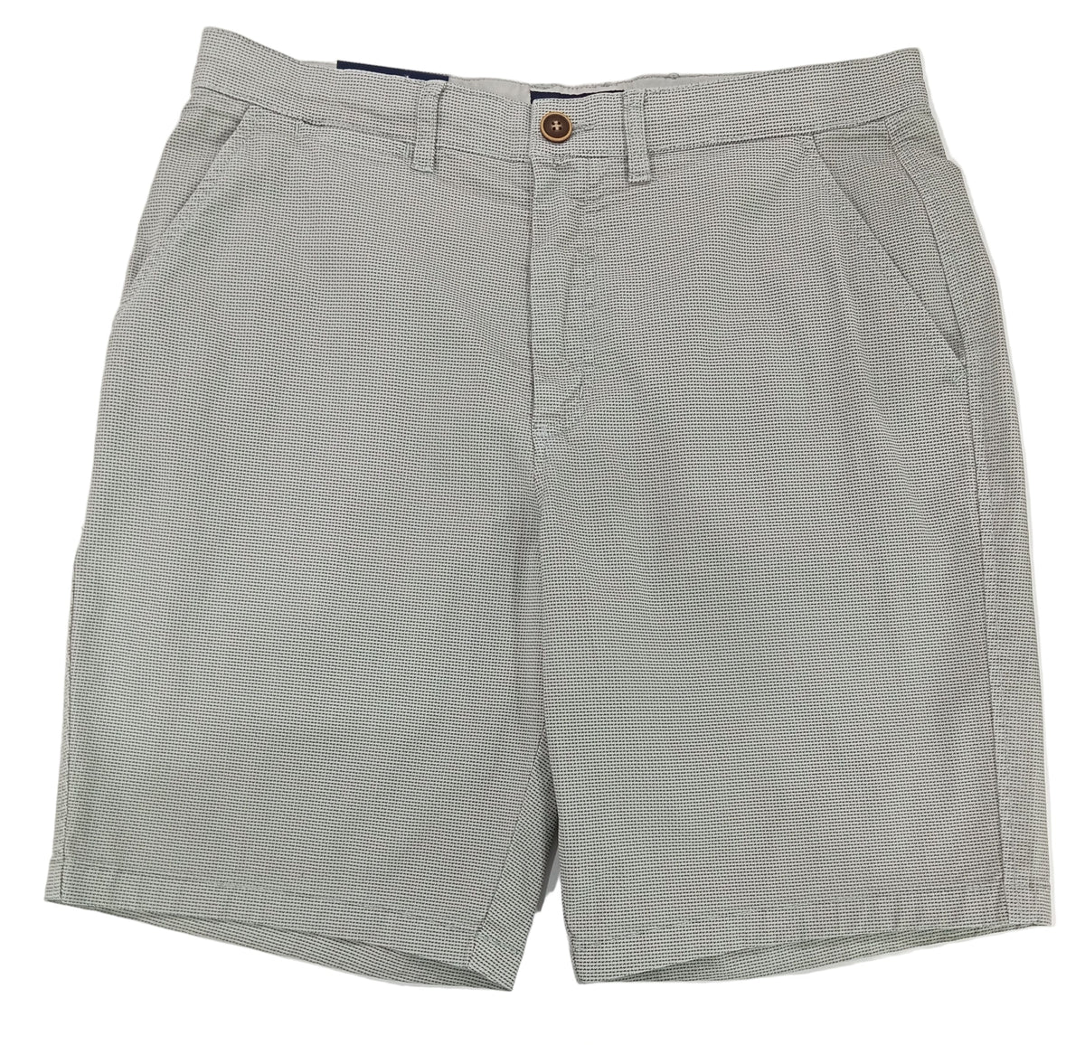 Gray shorts on a white surface with a textured wall background