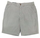 Gray shorts on a white surface with a textured wall background