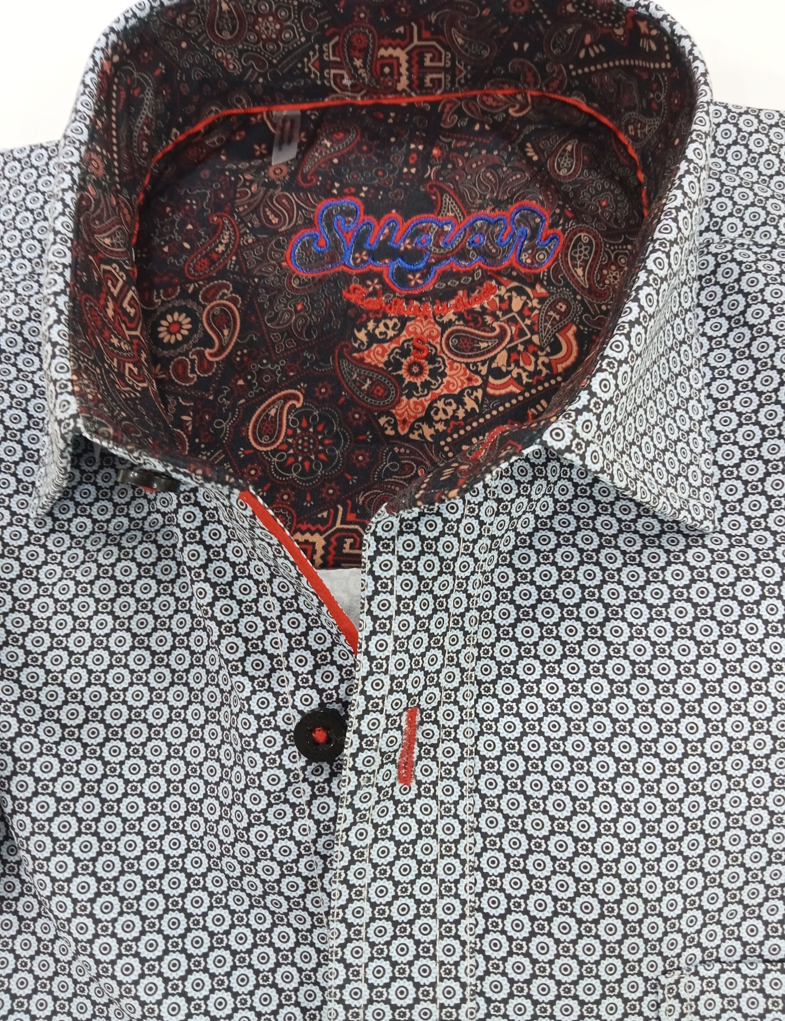 Patterned shirt with a decorative collar and visible brand name.