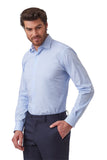 A man wearing a light blue long-sleeve dress shirt and dark navy trousers, photographed against a plain white studio background.