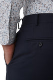 Navy pants with a patterned shirt worn by a person on a white background