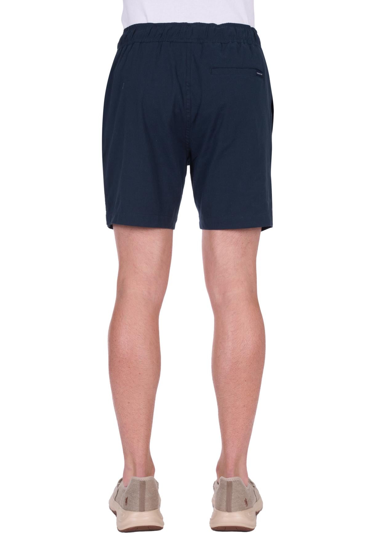 Navy blue shorts worn by a person on a white background