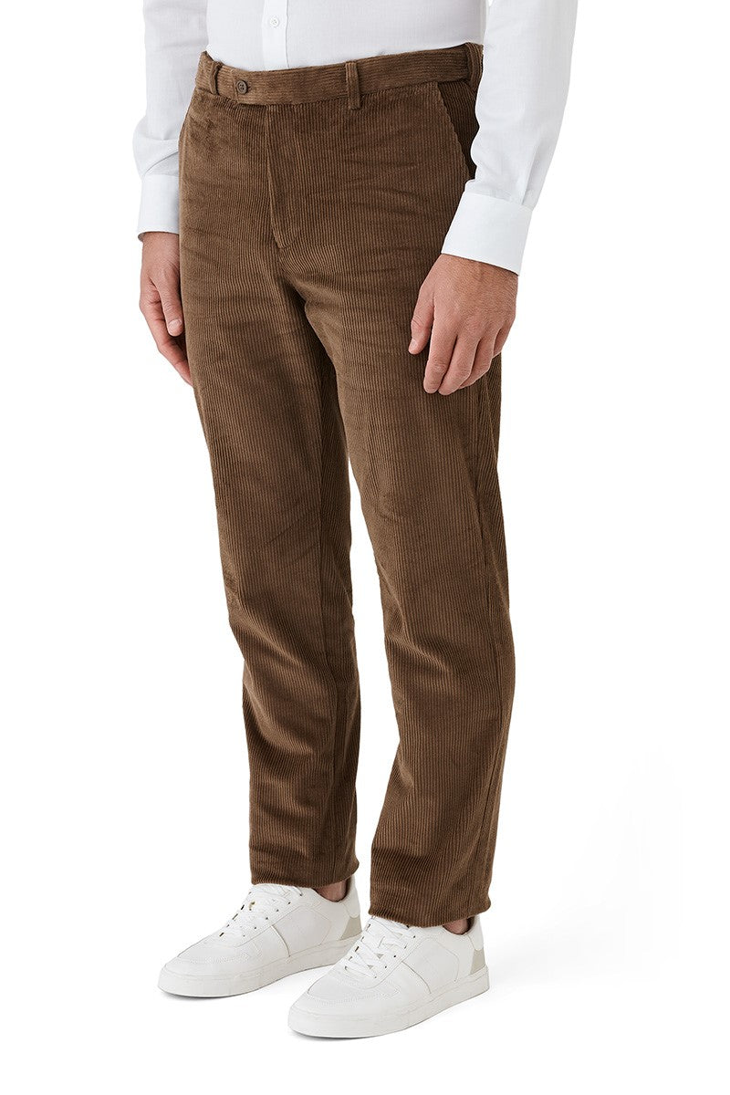 Brown corduroy pants worn with a white shirt and white sneakers on a white background