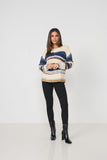 Woman wearing a striped sweater and black leggings on a white background