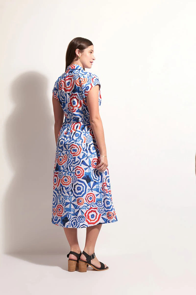 Woman wearing a blue patterned dress against a white background