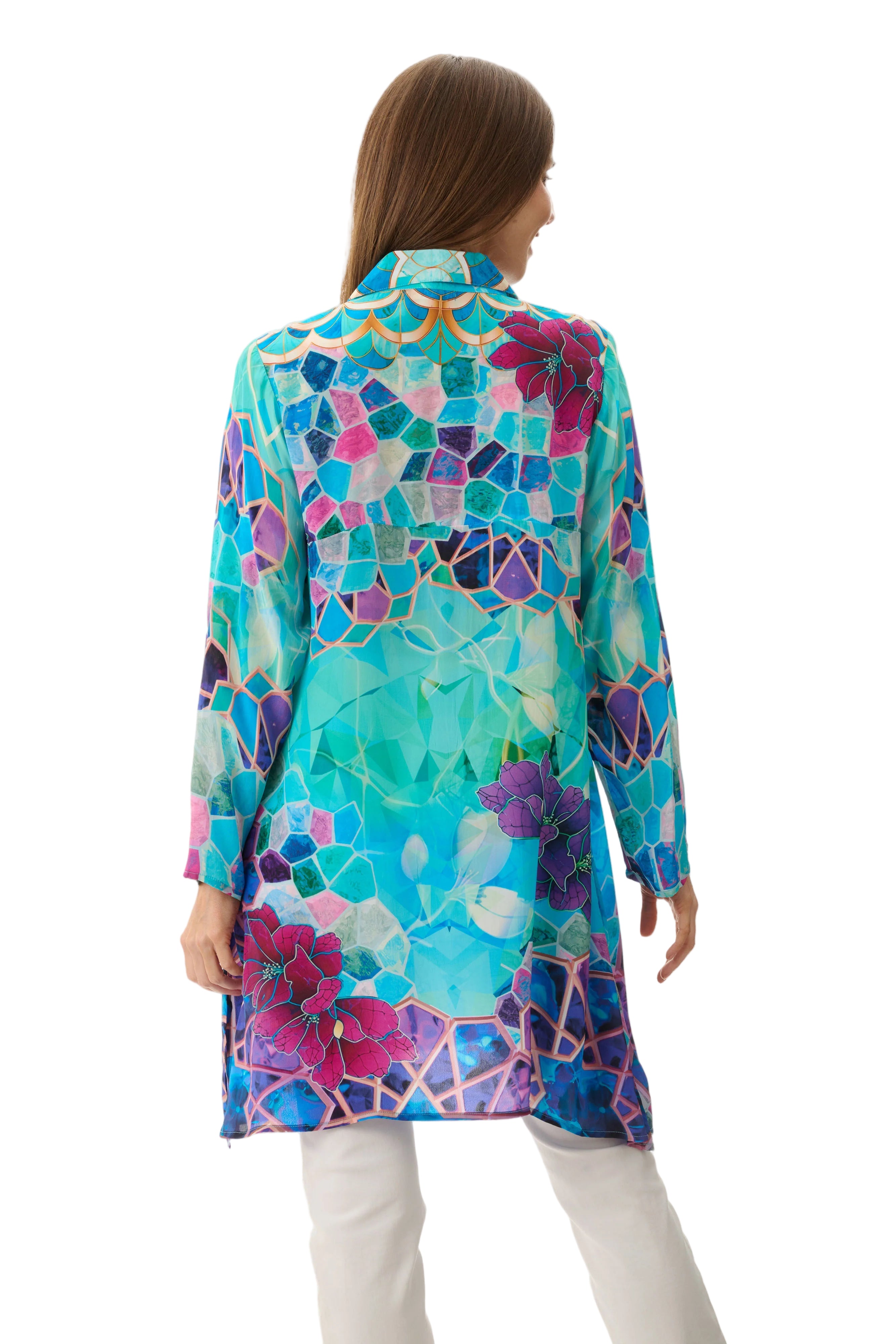 Woman wearing a colorful floral patterned shirt on a light background