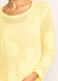 Yellow knitted sweater worn by a person on a light gray background