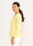 Woman wearing a light yellow sweater against a white background