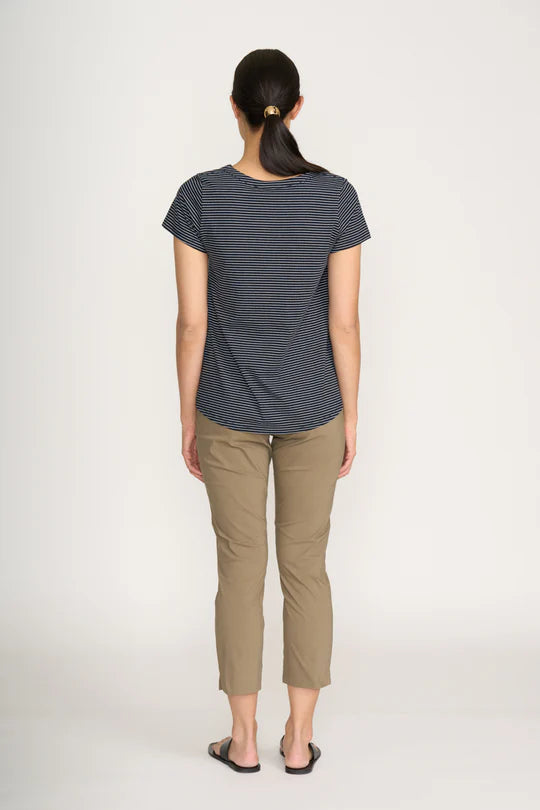 Woman wearing a striped shirt and beige pants on a white background