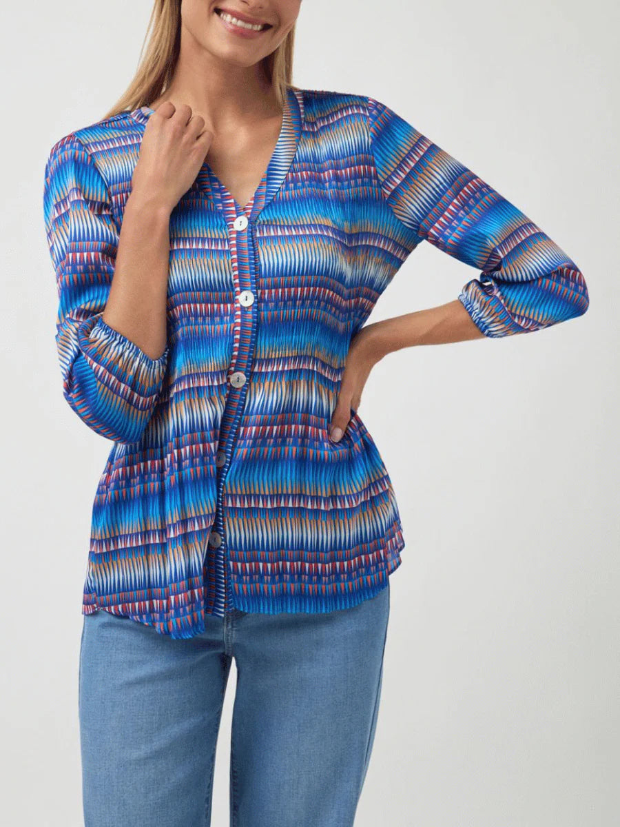 Woman wearing a blue patterned blouse and jeans on a white background