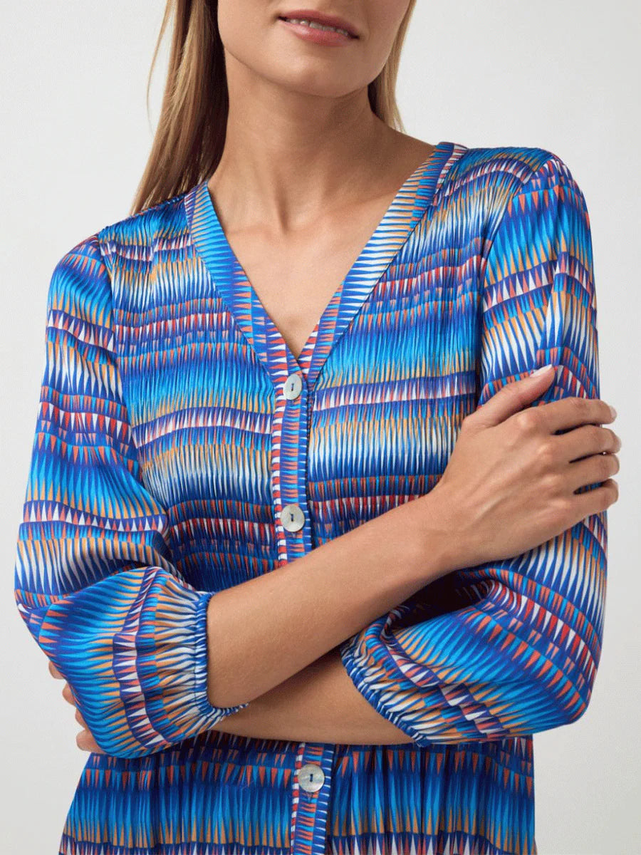 Woman wearing a blue patterned shirt with a white background
