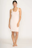Woman wearing a beige sleeveless dress on a white background
