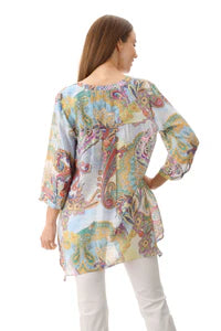 Woman wearing a colorful floral tunic on a white background