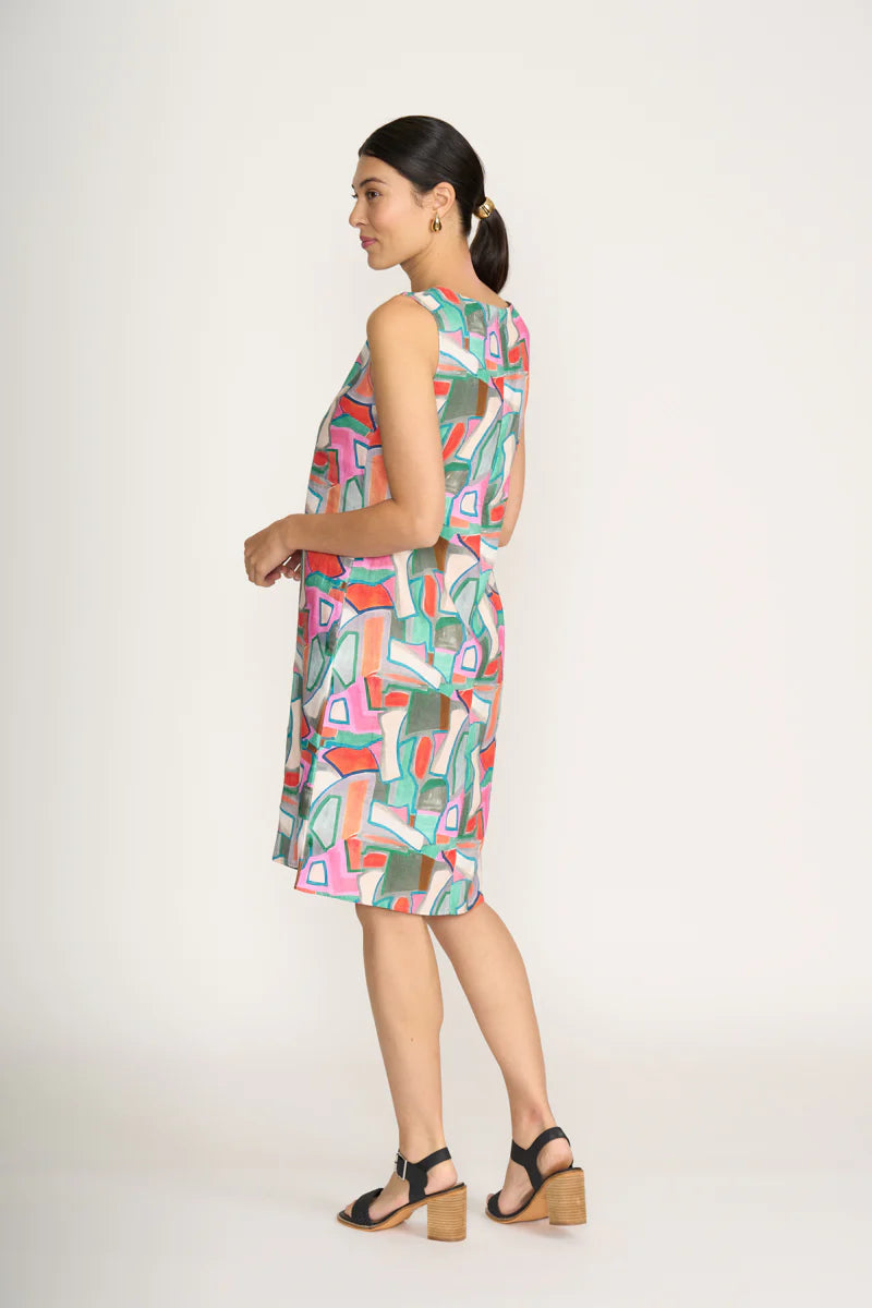 Woman wearing a colorful geometric patterned dress on a white background