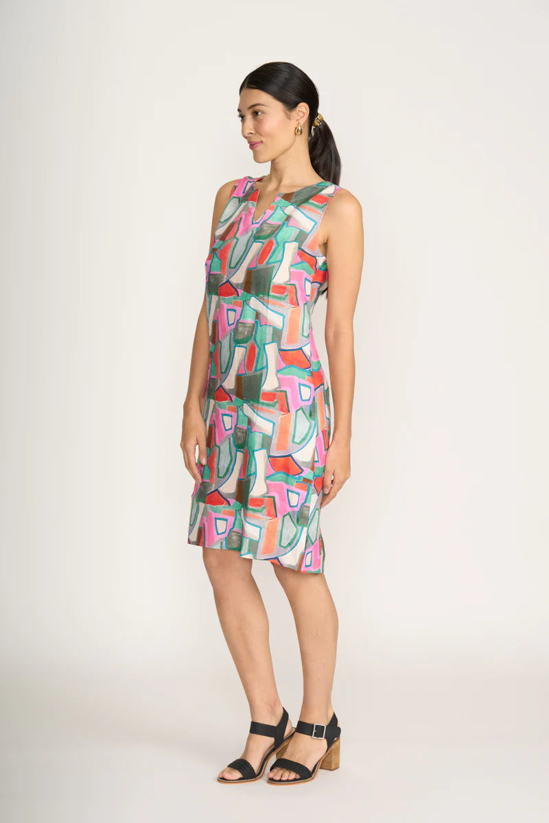 Woman wearing a colorful geometric-patterned dress on a white background