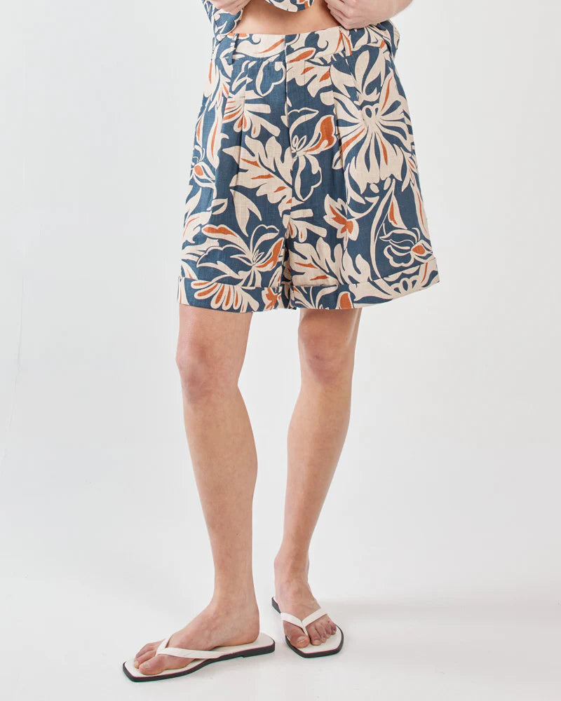 Person wearing a blue floral patterned skirt on a white background
