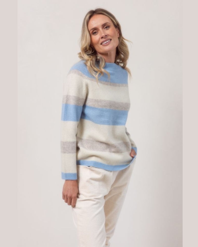 Woman wearing a striped sweater with a plain background