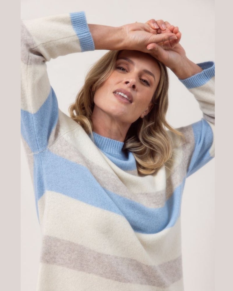 Woman wearing a striped sweater with a white background