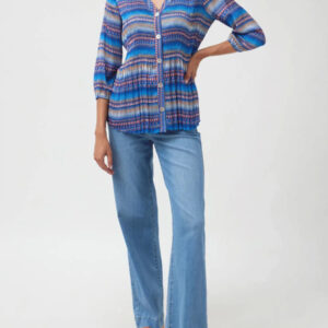 Woman wearing a blue patterned shirt and jeans on a white background